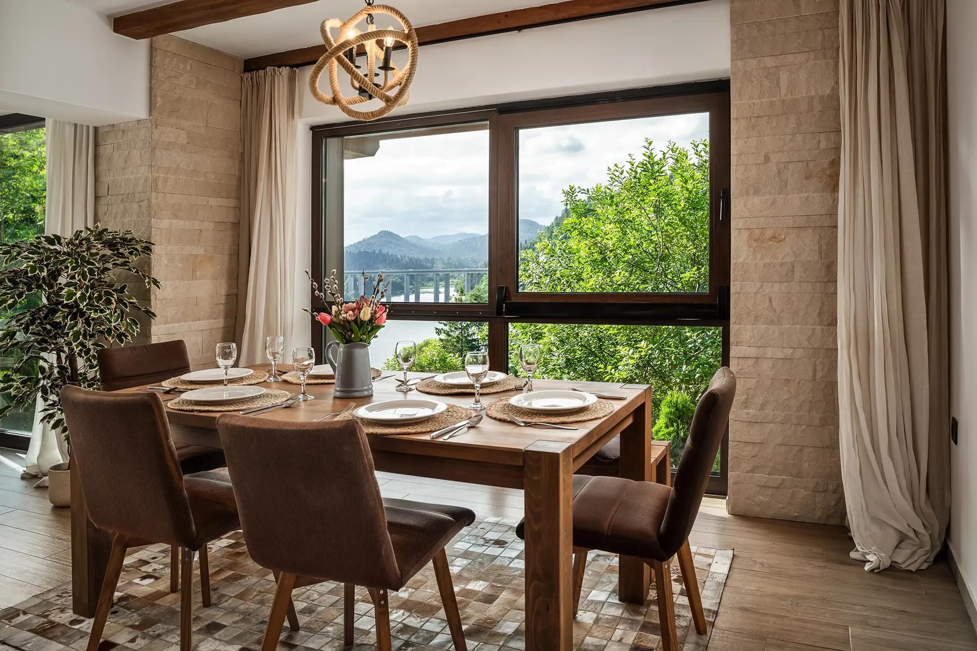 Blagovaonički stol postavljen za večeru s pogledom na jezero i planine