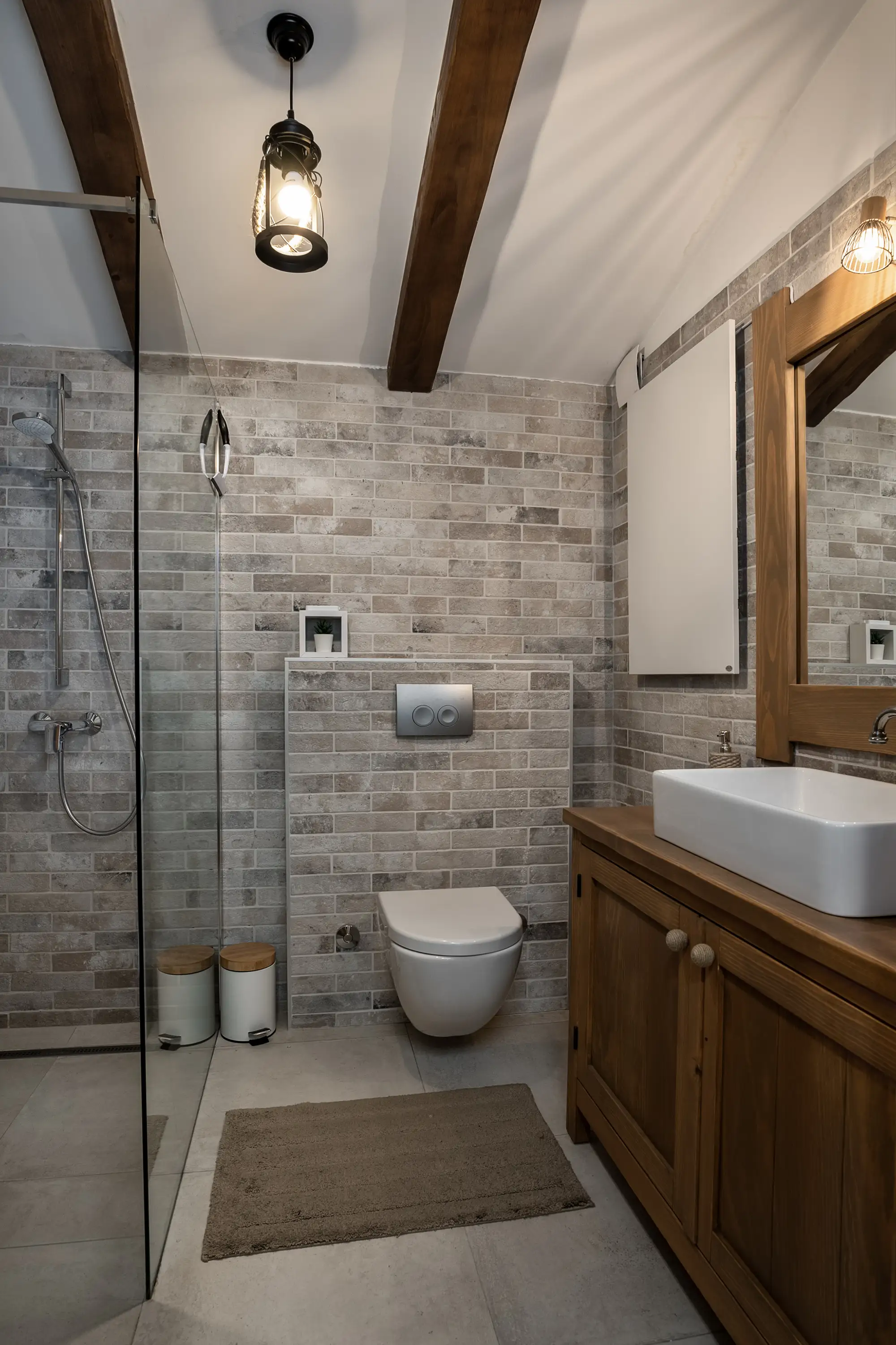 Kupaonica s pločicama od prirodnog kamena, staklenim tuš-kabinom i hrastovim umivaonikom