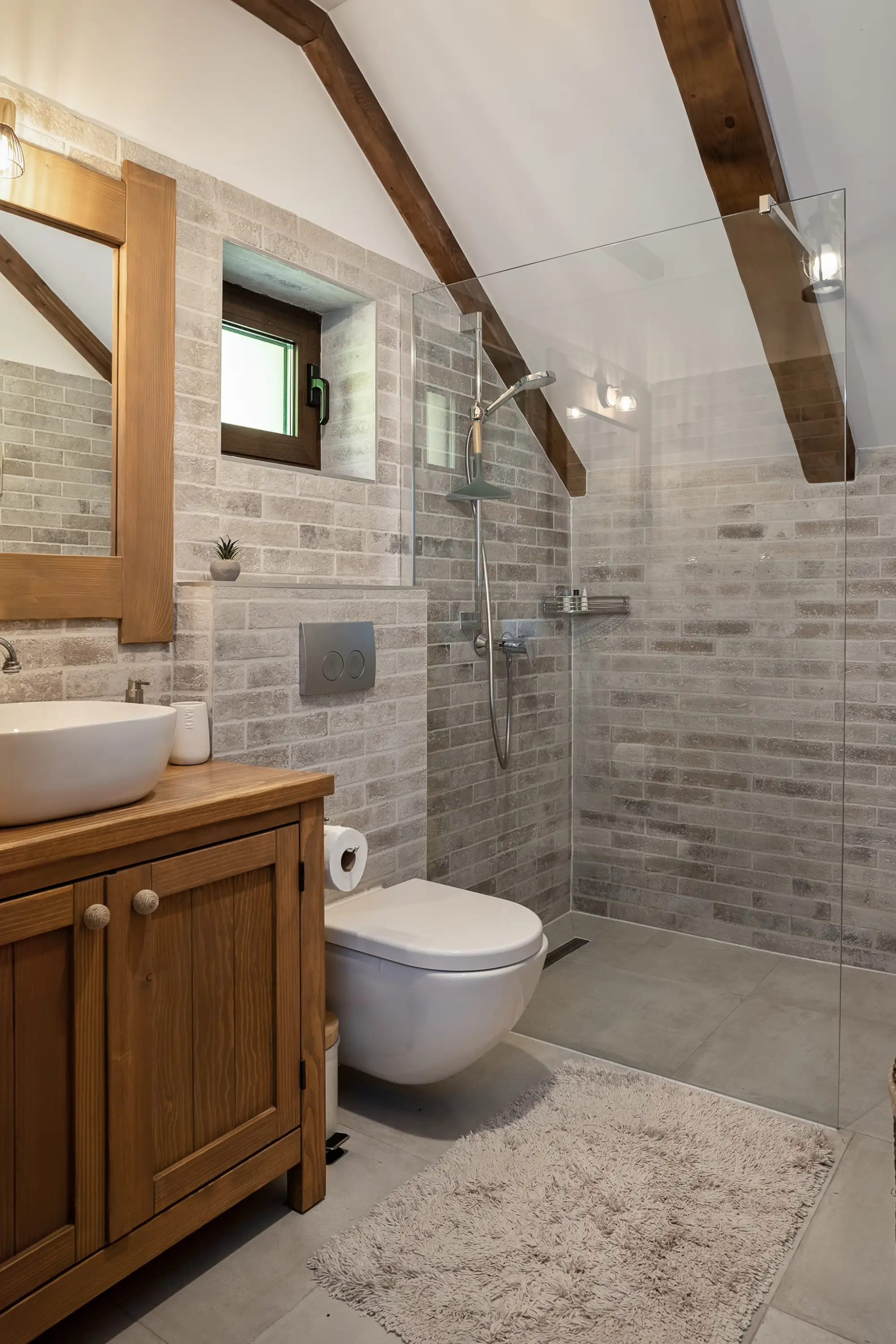 Potkrovna kupaonica s tuš-kabinom, drvenim gredama i hrastovim umivaonikom